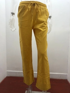 Detail view of bright yellow cotton linen trousers with elastic drawstring waistband