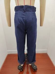 Detailansicht der hoch taillierten dunkelblauen Cordhose mit Schnallenverzierung