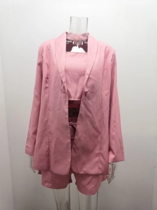 Vista dettagliata del completo rosa tre pezzi con blazer, crop top e pantaloncini a vita alta