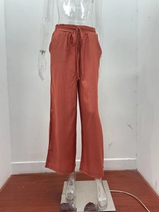 Dettaglio di pantaloni arancioni a gamba larga a vita alta con coulisse e tessuto morbido