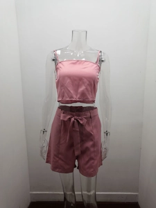 Dettaglio di un completo rosa tre pezzi con top corto e pantaloncini con cintura