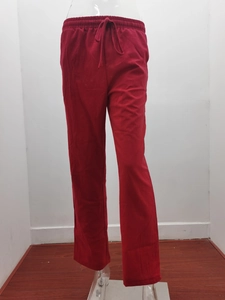 Detail view of red linen drawstring trousers with elastic waistband and straight leg cut
