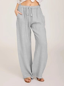 Detail of high-waist elastic waistband with drawstring on light gray linen trousers