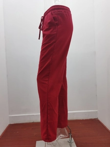 Detail view of red cotton linen trousers with elastic drawstring waist and side pockets