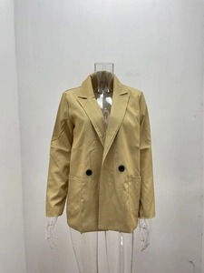 Close-up of light khaki double-breasted blazer showing notch lapels and textured fabric