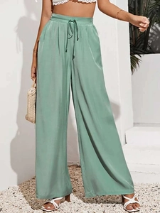Dettaglio di pantaloni larghi a vita alta verde chiaro con coulisse in stile resort