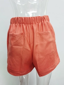 Rear view of orange casual shorts showing elastic waistband and two large back pockets