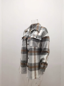Detail of grey plaid woolen jacket featuring twin chest pockets and button-down front