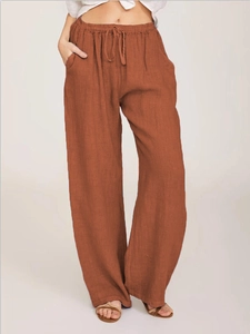 Detail of rust red cotton linen trousers showing the elastic waist and drawstring