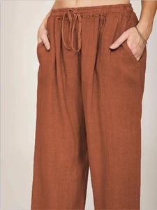 Detail of loose fit cotton linen pants featuring elastic waistband and functional pockets