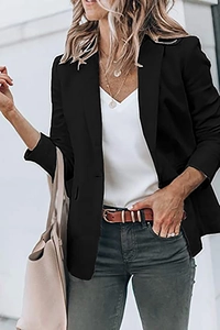Detail of single-breasted black blazer styled with jeans and brown belt in street setting