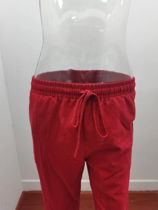 Detailed view of elastic drawstring waistband on red cotton linen wide leg trousers