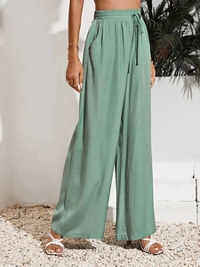 Dettaglio dei pantaloni larghi verde salvia a vita alta con coulisse elastica e tasche