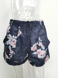 Detail view of navy blue floral shorts with elastic drawstring waist and side pockets