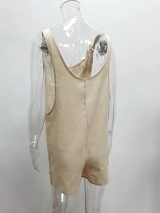 Dettaglio della tutina in cotone e lino albicocca con design posteriore e tessuto naturale