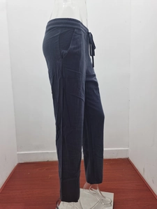Detailed view of the drawstring elastic waist and side pockets on navy cotton linen pants