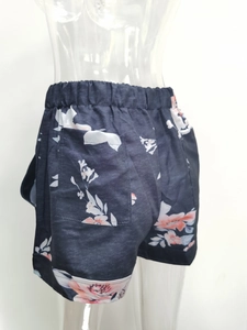 Detail of high waisted floral shorts showing elastic waistband and side patch pocket
