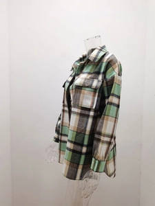 Detailed macro view of the thick checkered flannel fabric texture and chest pocket on shirt
