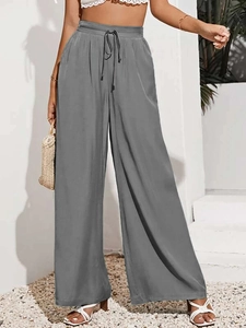 Dettaglio dei pantaloni a gamba larga grigio scuro a vita alta con coulisse elastica
