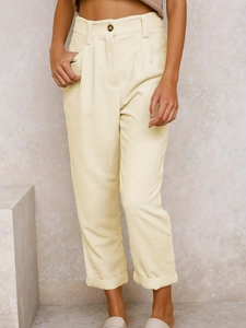 Detail der hoch taillierten Cordhose mit Falten vorne und festen Umschlägen in Creme-Beige