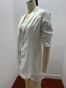 Dettaglio del blazer bianco da donna con revers a lancia e maniche arricciate