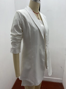 Dettaglio del blazer bianco con revers a lancia e bottone singolo in tessuto setoso leggero
