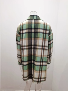 Detail of plaid wool jacket showing green and white checkered pattern and thick fabric