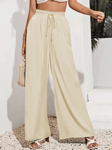 Dettaglio della vita alta con coulisse e consistenza del tessuto su pantaloni larghi beige