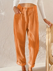 Detailansicht der orangefarbenen Cordhose mit hoher Taille und Rippstruktur