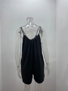 Detail of black V-neck camisole romper with fine straps and pleated neckline details