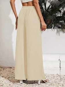 Dettaglio posteriore di pantaloni beige a vita alta con elastico in vita arricciato