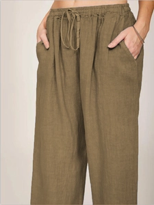 Detail of loose fit cotton linen pants featuring elastic drawstring waist and side pockets