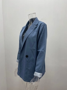 Detailed close-up of sky blue women's blazer featuring notch lapels and double-breasted buttons