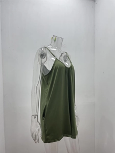 Detail view of green V-neck romper featuring adjustable straps and functional side pockets