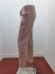 Detailed side view of loose linen trousers with elastic drawstring waist and side pockets