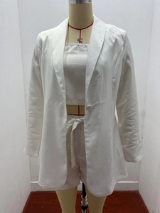 Dettaglio del completo bianco a tre pezzi con blazer, top e pantaloncini con cintura