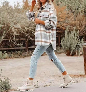 Detail of grey plaid woolen shacket with button-down pockets and curved hem