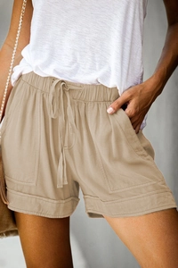 Close-up of khaki high-waisted shorts with drawstring elastic waist and large side pockets