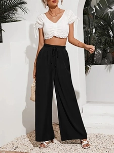 Dettaglio della vita alta elastica con coulisse sui pantaloni neri larghi estivi