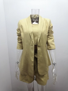 Dettaglio del completo tre pezzi kaki con blazer, top a fascia e pantaloncini