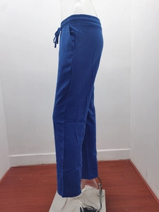 Detail view of blue cotton linen trousers with elastic drawstring waist and side pockets