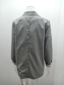 Detail view of grey blazer back showing professional stitching and contrast folded cuffs