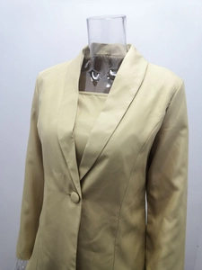 Dettaglio macro del blazer kaki con collo a scialle, trama in twill e bottone
