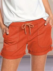Dettaglio degli shorts casual arancioni con coulisse in vita e grandi tasche applicate