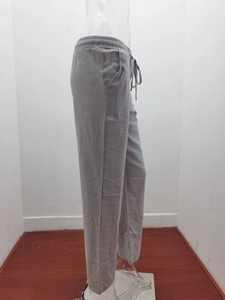 Detail view of grey cotton linen trousers with elastic drawstring waist and side pockets