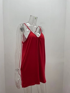 Detailed close-up of a red V-neck romper with thin straps and delicate pleated chest details
