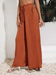 Dettaglio dei pantaloni larghi a vita alta marrone-arancio con coulisse elastica