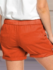 Dettaglio dei pantaloncini casual arancioni con vita elastica e bottoni laterali