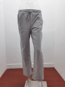 Detail view of light grey linen trousers featuring an adjustable drawstring elastic waistband