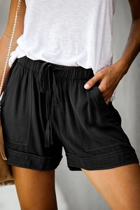 Detail of high waist black shorts with drawstring elastic waist and large front pockets